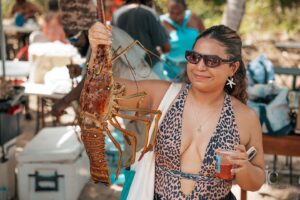 woman holding whole lobster at festival